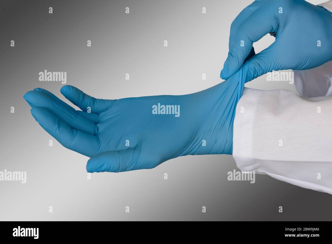 Persona che indossa guanti chirurgici blu Foto Stock