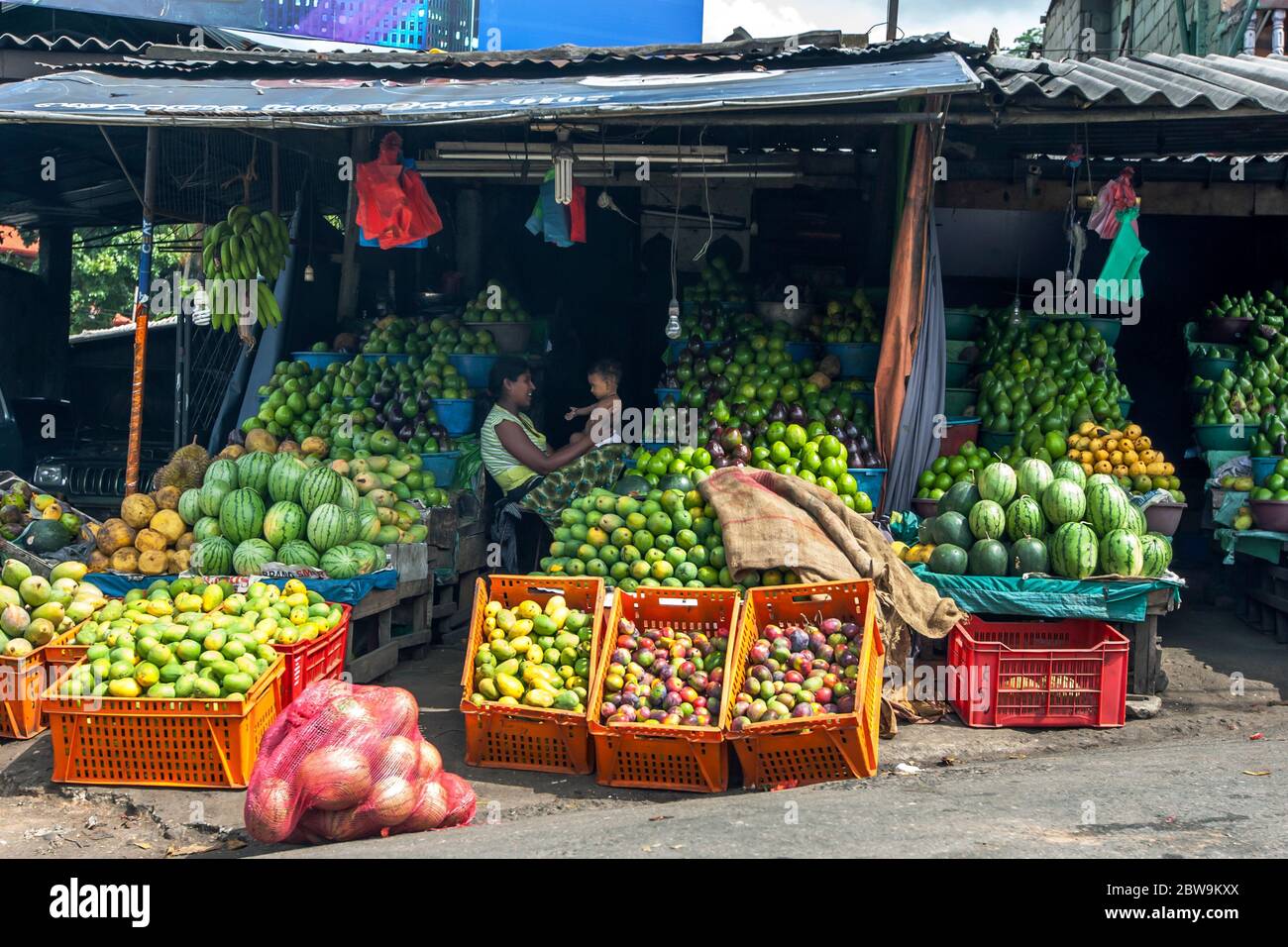 Bancarelle di frutta fresca situate sulla strada a Kandy in Sri Lanka. Vendono vari meloni e frutta verde. Foto Stock