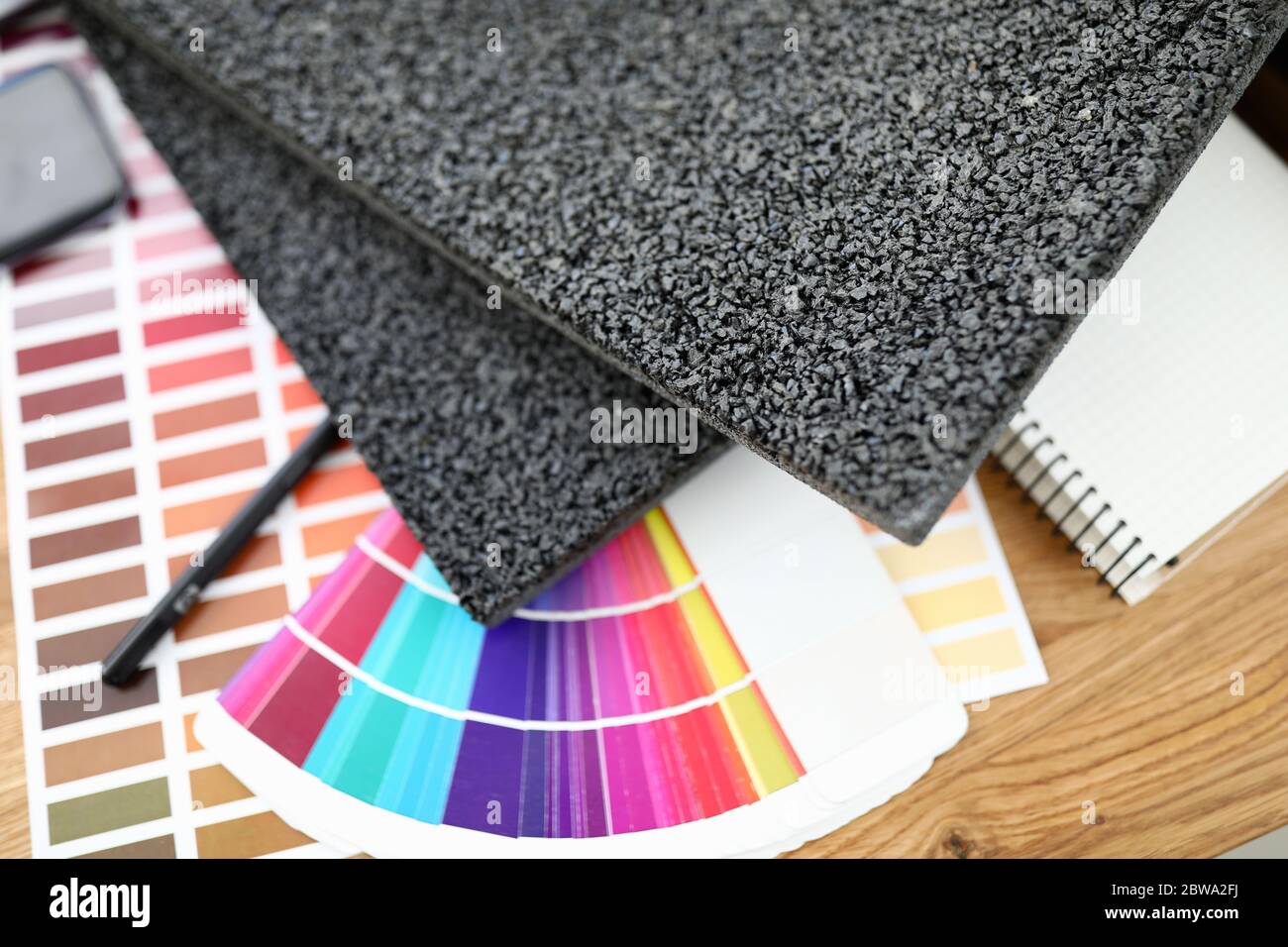 Sul tavolo sono presenti dei campioni di tappeti con colori luminosi Foto Stock