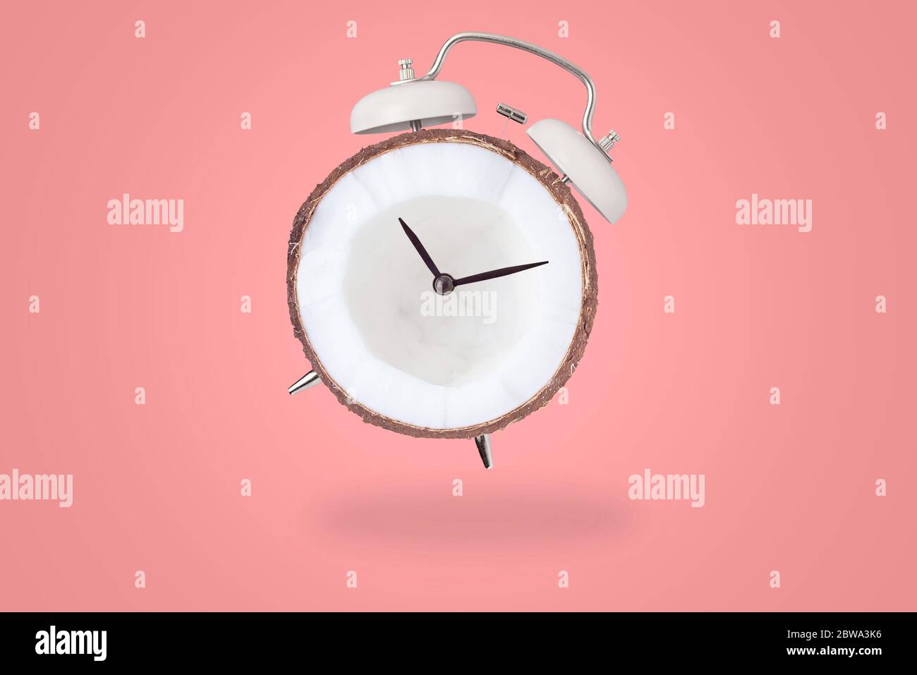 Sveglia con quadrante di cocco su sfondo rosa. Concetto di stile creativo minimal Foto Stock