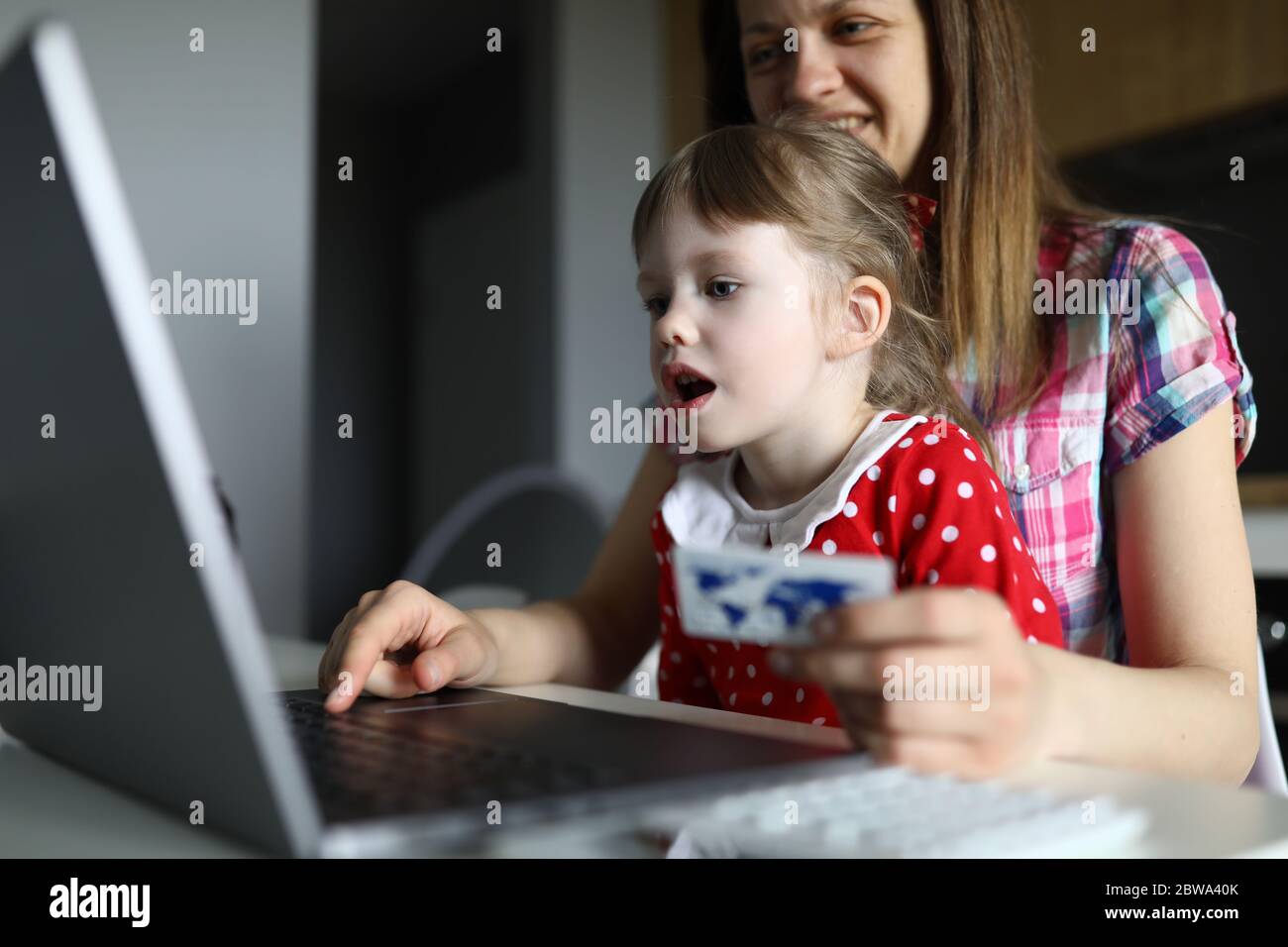 Donna con bambino a casa inserire carta di credito online Foto Stock