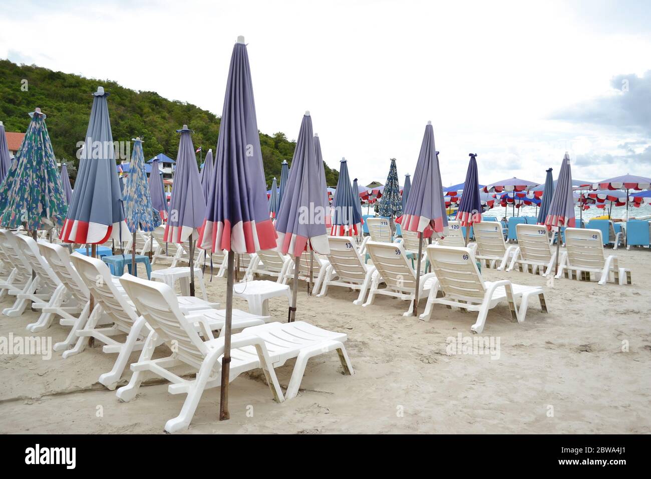 Sedie a sdraio o ombrelloni sulla spiaggia sabbiosa dell'isola di Koh Larn, Pattaya, Thailandia. Ideale per chi viaggia per rilassarsi su un perfetto vac Foto Stock