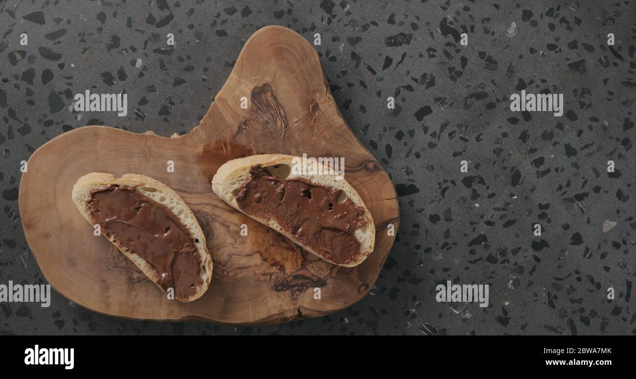 cioccolato spalmato su fetta di ciabatta sulla vista dall'alto dell'ulivo Foto Stock