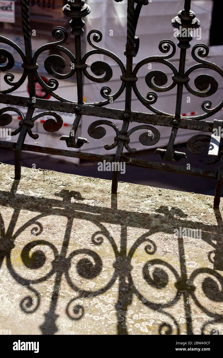 Ringhiera storica rustica su un balcone formando splendidi motivi d'ombra Foto Stock