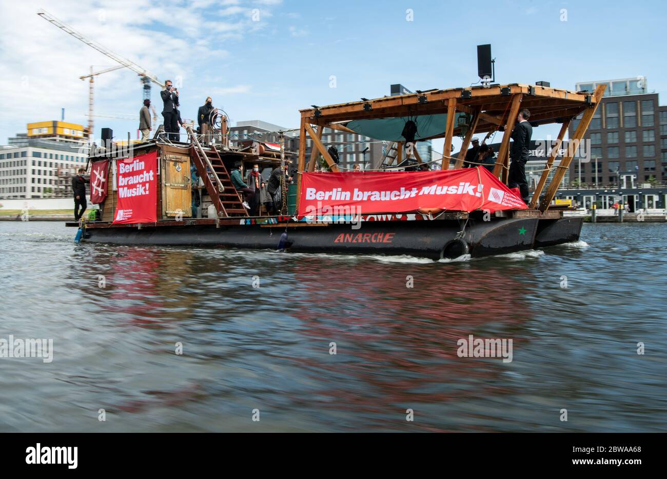 Berlino, Germania. 31 maggio 2020. Un ensemble del Deutsches Symphonie-Orchester (DSO) corre su una zattera attraverso lo Sprea presso la East Side Gallery. Sotto il motto "Berlino ha bisogno di musica!" i musicisti d'orchestra vogliono sottolineare che l'esperienza della musica dal vivo non è un lusso, ma un bisogno umano esistenziale. Inoltre, va ricordata la difficile situazione dei musicisti e delle altre persone coinvolte in eventi di concerto a causa di restrizioni correlate alla corona. Credit: Bernd von Jutrczenka/dpa/Alamy Live News Foto Stock