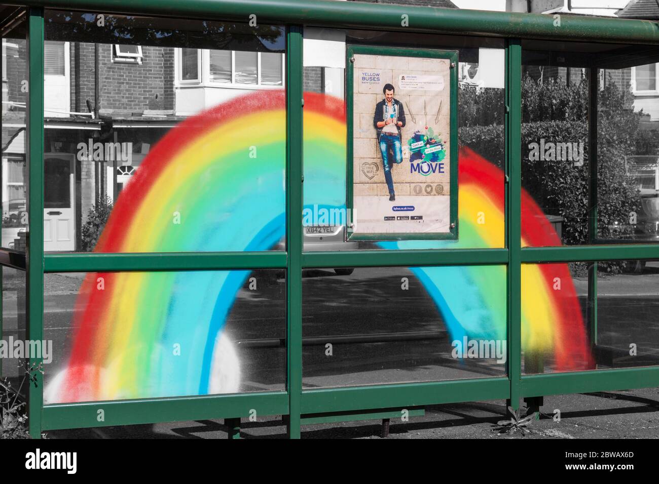 Rainbow dipinto sul riparo fermata autobus a Bournemouth, Dorset UK nel mese di maggio per mostrare il sostegno al NHS durante la pandemia di Coronavirus con poster giallo autobus Foto Stock