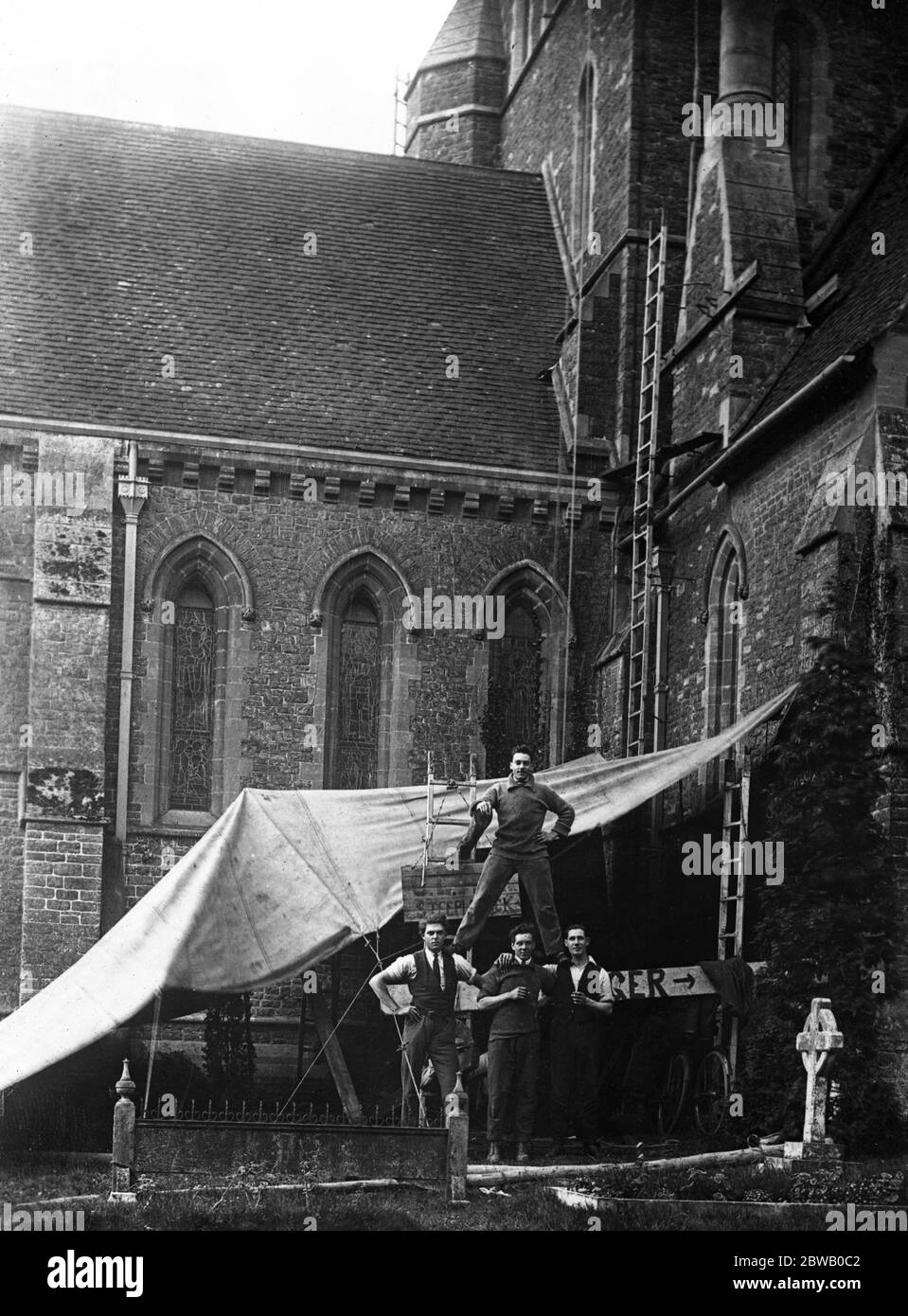 Il signor C L Ager, il campanile, con i suoi assistenti, che sono stati attaccati da formiche rosse sulla guglia della Chiesa di Shackleford, vicino ad Aldershot. 1922 Foto Stock