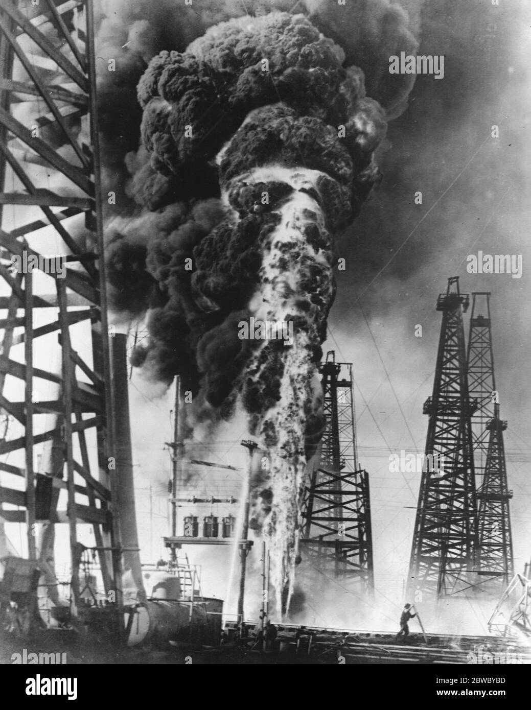 Spettacolo impressionante fornito dal fuoco del pozzo del petrolio. Uno dei pozzi del mandrino Top campo che sgorga olio di flaming e acrid fumo durante l'incendio che si è verificato di recente . 26 novembre 1926 Foto Stock