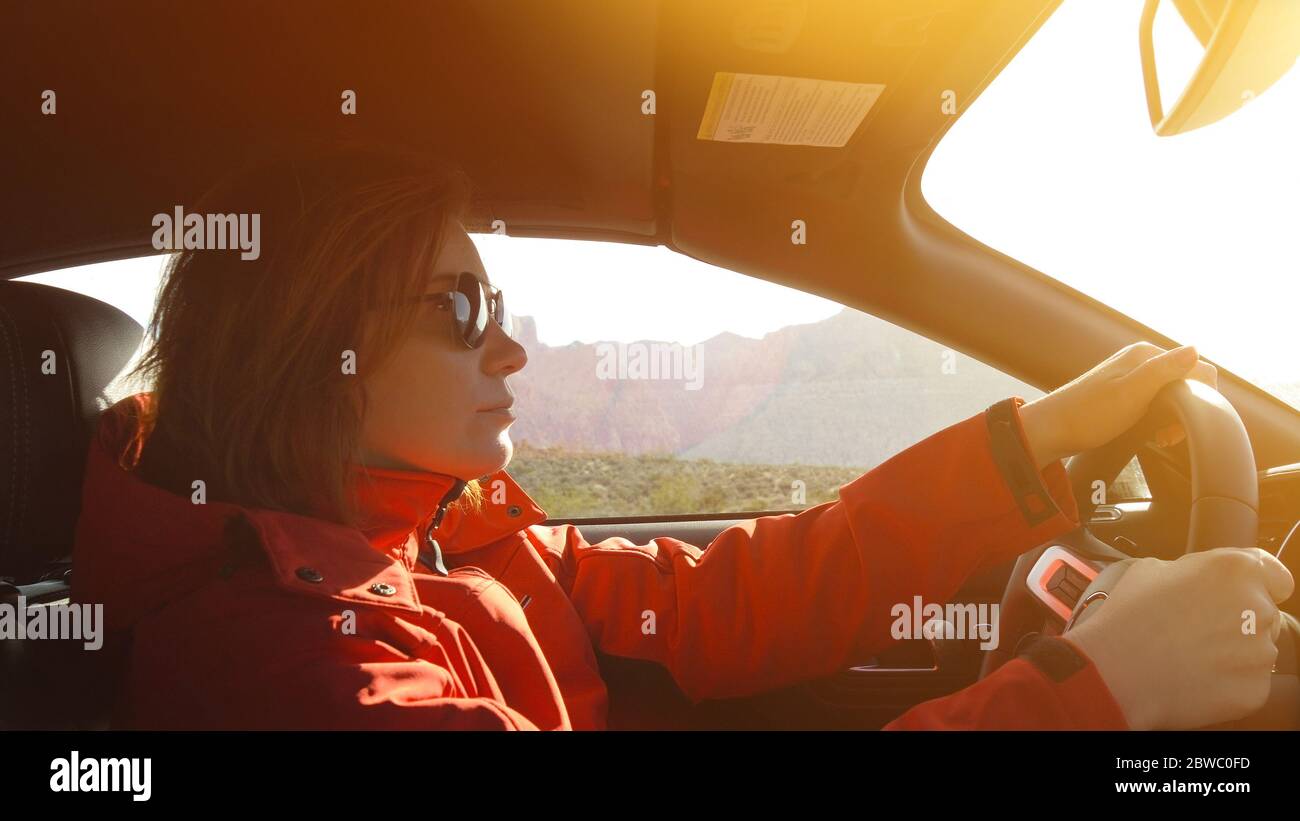 Donna con un aspetto serio alla guida di un'auto. Foto Stock