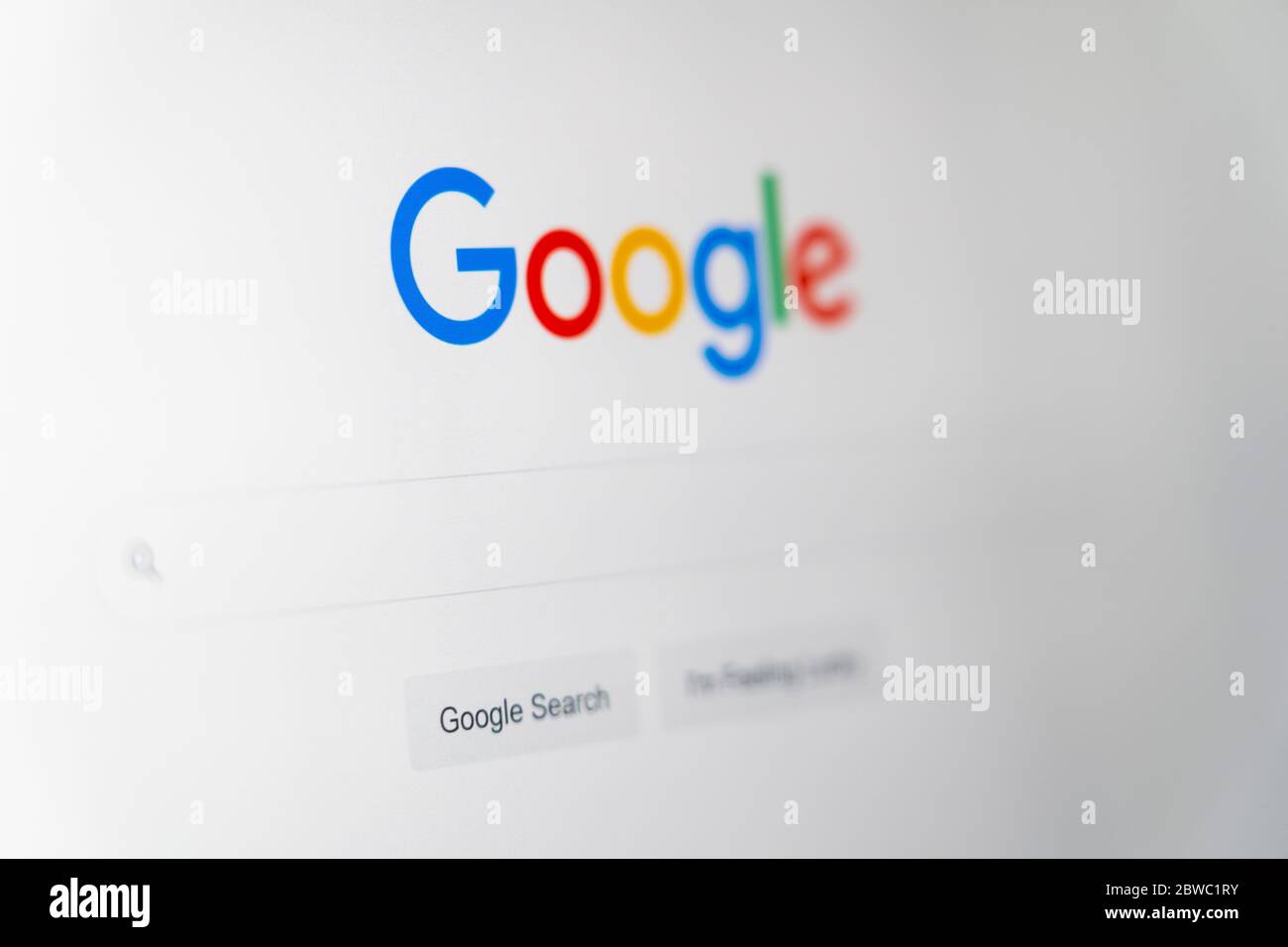 Il sito web della homepage di Google con il logo Google, la barra di ricerca e mi sento fortunato pulsante in lingua inglese su uno schermo del computer Foto Stock