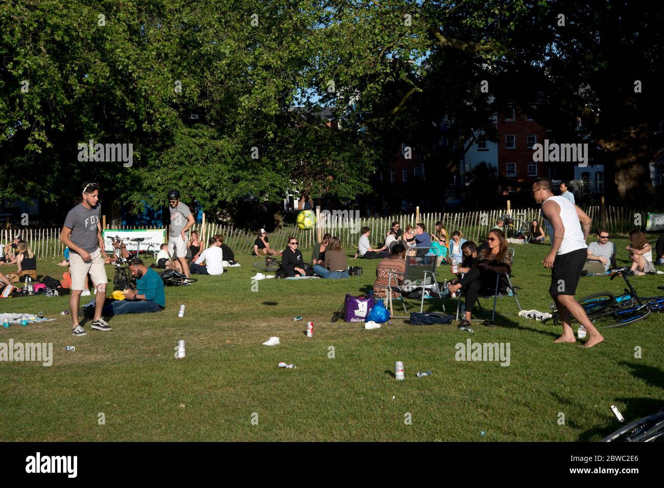 Hackney, Londra, maggio 2020 durante la pandemia di Covid-19 (Coronavirus). Campi di Londra. Un gruppo di giovani uomini gioca una partita a palla con lattine di birra come marcatori. Foto Stock