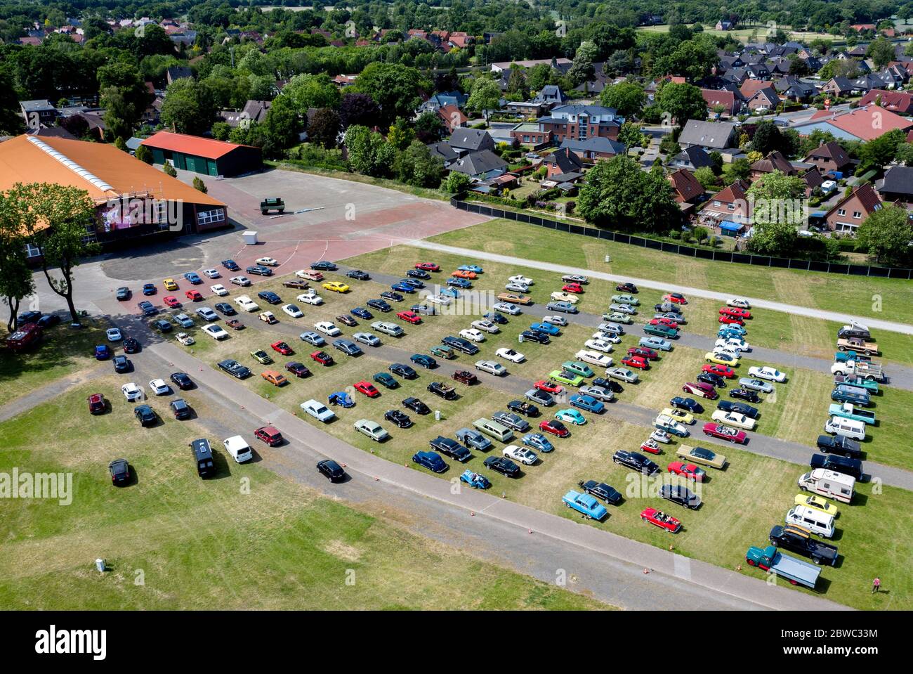 Hude, Germania. 31 maggio 2020. Le auto d'epoca sono parcheggiate nel parco di un cinema drive-in nel quartiere di Wüsting. (girato con un drone). Diverse centinaia di persone nei loro vecchi, giovani e automobili classiche americane hanno partecipato all'evento nel quartiere di Oldenburg. I fan delle auto classiche hanno guardato il film "le Mans 66 - contro tutte le probabilità" in circa 200 veicoli storici. Credit: Hauke-Christian Dittrich/dpa/Alamy Live News Foto Stock