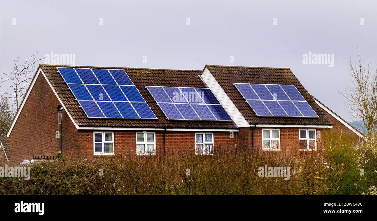 Foto di pannelli solari sul tetto di case a schiera che forniscono una fonte di energia rinnovabile. Foto Stock