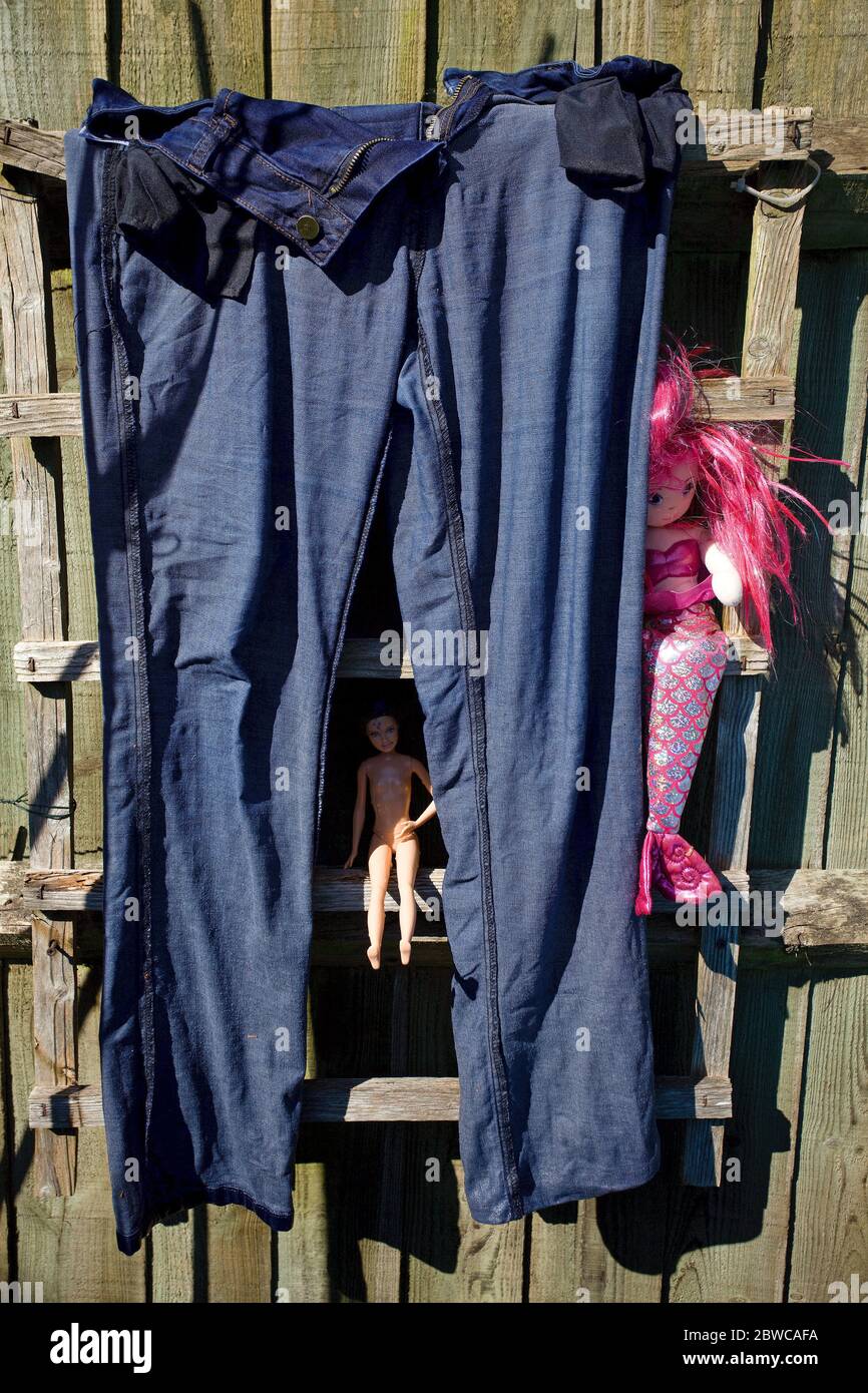 Jeans bagnati che asciugano al sole con i giocattoli del bambino Foto Stock