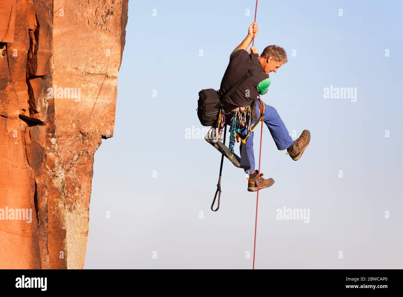 Scalatore e fotografo Norbert Frank salendo una roccia su una corda Foto Stock