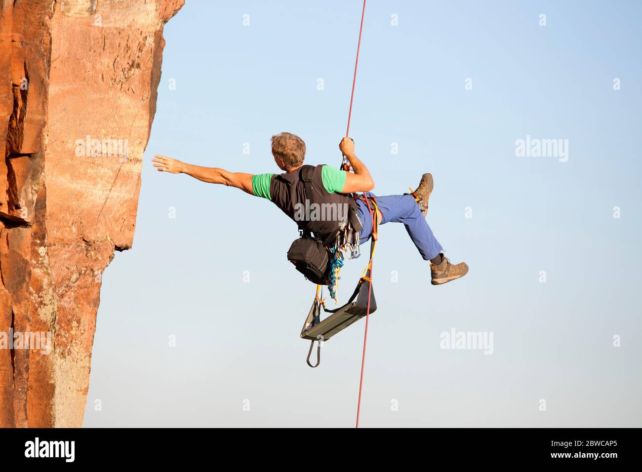 Scalatore e fotografo Norbert Frank salendo una roccia con una corda Foto Stock