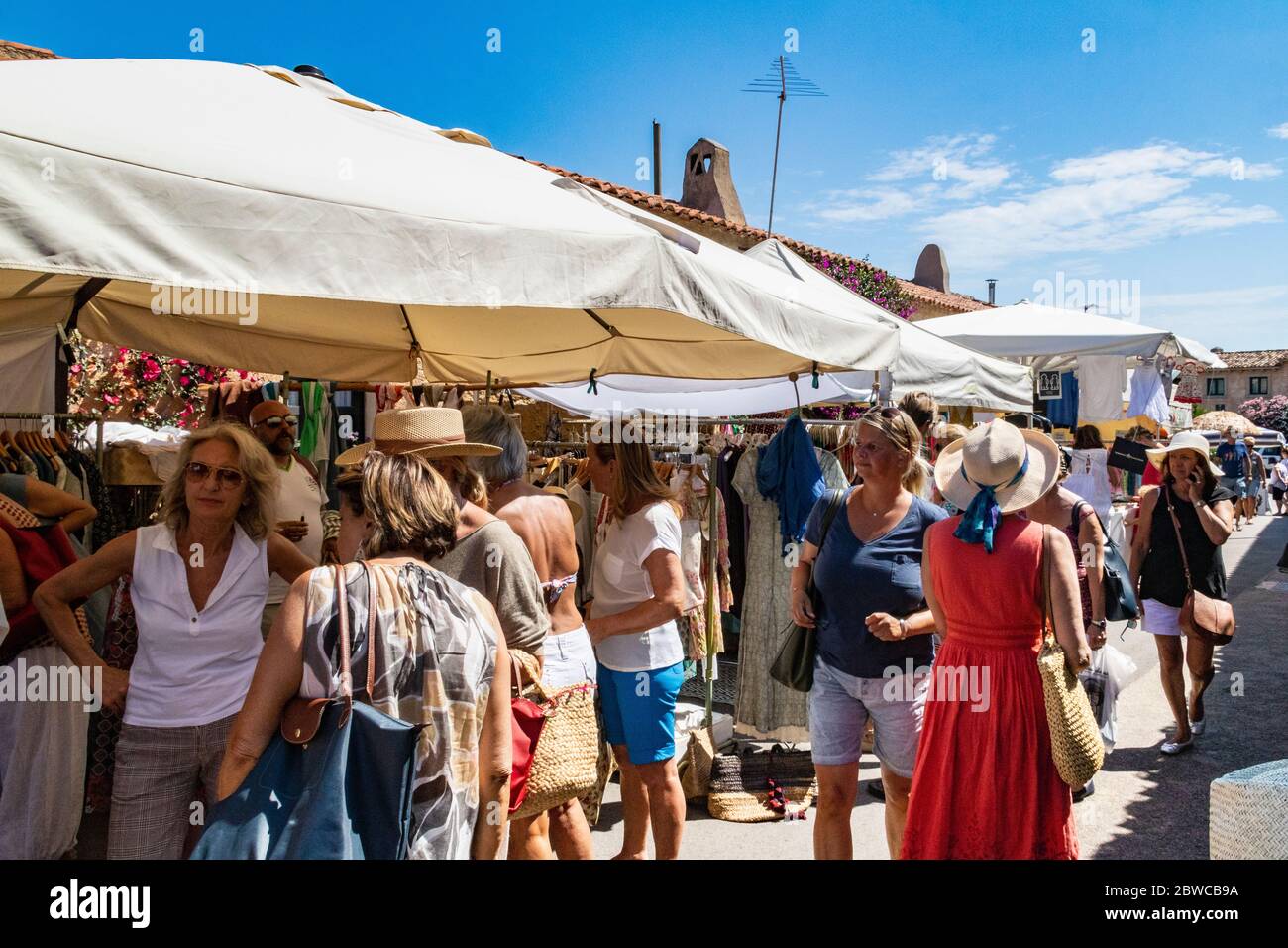 Shopping in un mercato occupato: Scena con i visitatori curiosare tra le bancarelle in un mercato estivo settimanale e chiacchierare a San Pantaleo, Gallura, Sardegna, Italia. Foto Stock