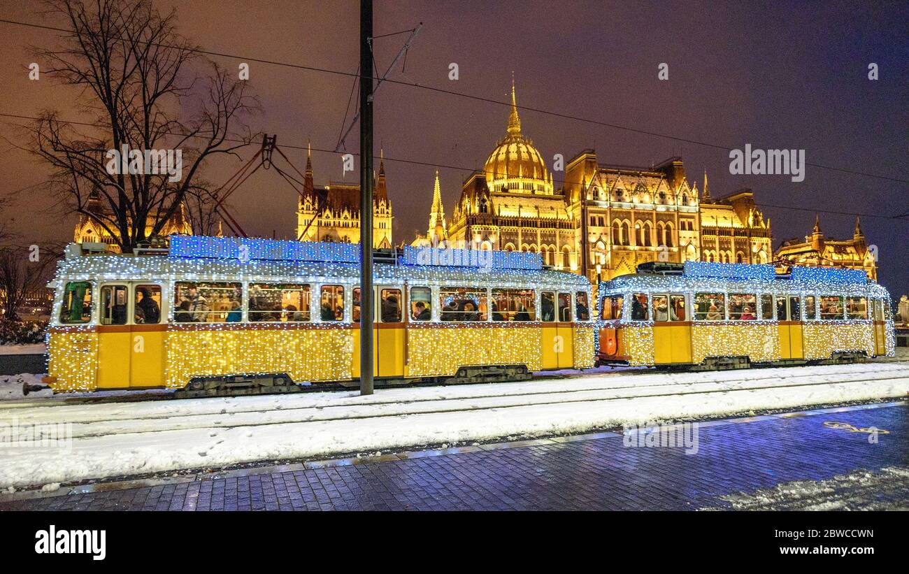 Il tram di Natale passa davanti all'edificio del Parlamento ungherese Foto Stock