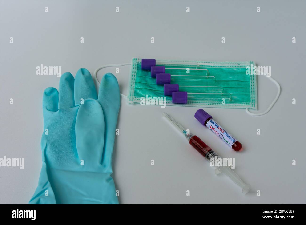 Campioni di analisi del sangue per la presenza di Coronavirus (COVID-19). La siringa e la provetta contenenti un campione di sangue che ha dato esito positivo al test COVID-19. Foto Stock