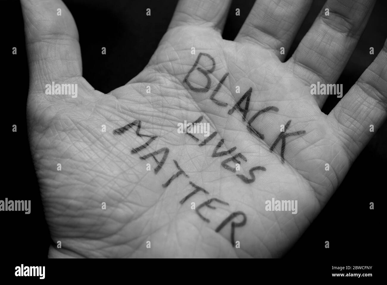 Primo piano di una mano bianca con parole Black Lives Matter. I bianchi in solidarietà con i neri Americani per porre fine alla brutalità della polizia Foto Stock