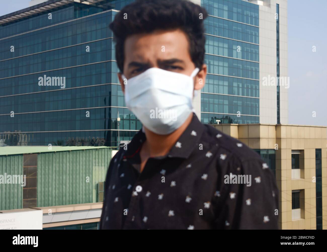 Giovane uomo con maschera medica. Background aziendale. Fuoco selettivo sullo sfondo. Foto Stock