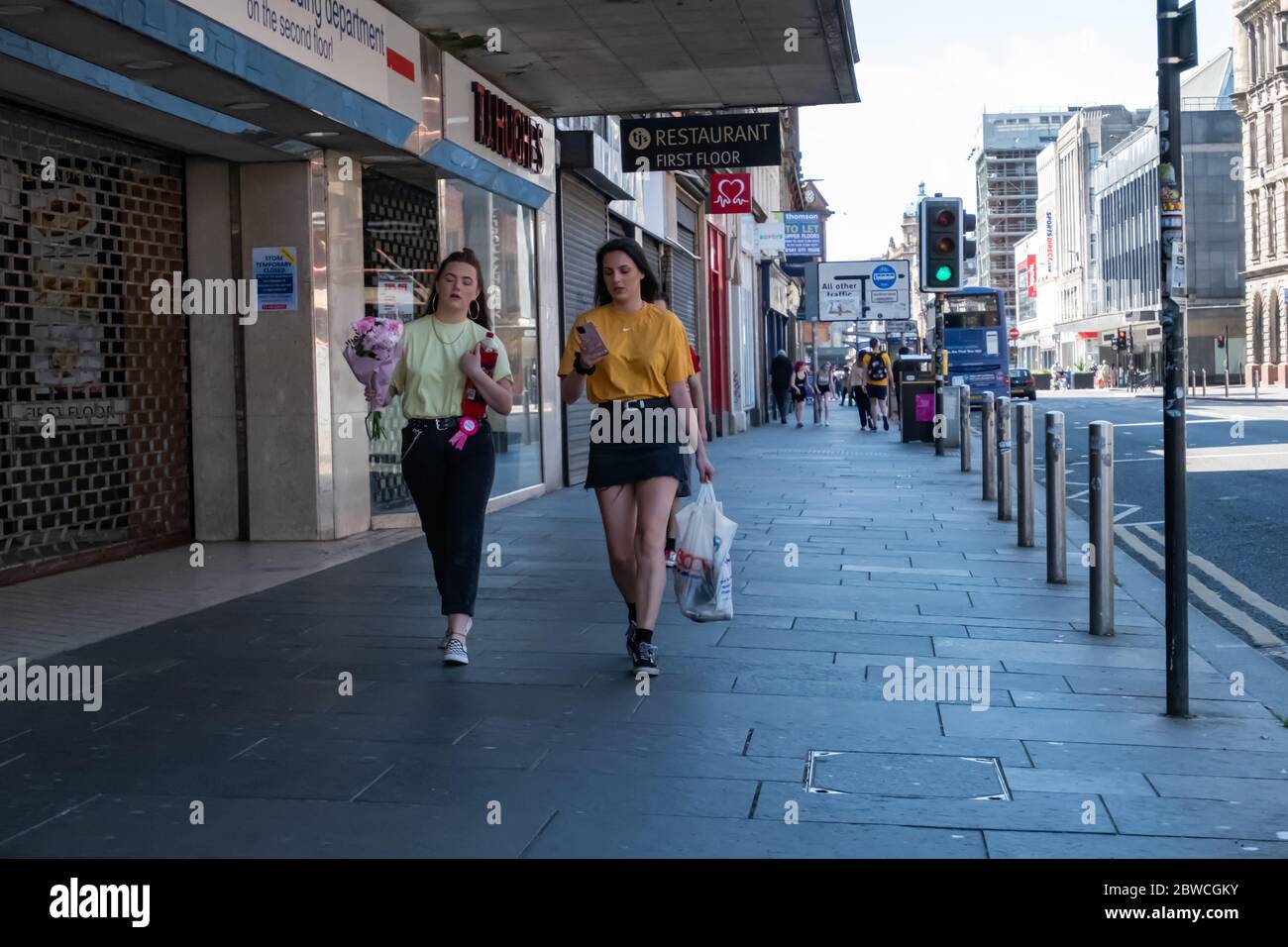 Glasgow, Scozia, Regno Unito. 31 maggio 2020. Due ragazze che camminano lungo Trongate in un caldo e soleggiato pomeriggio di domenica. Il governo scozzese ha annunciato il 28 maggio un allentamento delle regole di blocco del coronavirus. Credit: Notizie dal vivo SKULLY/Alamy Foto Stock