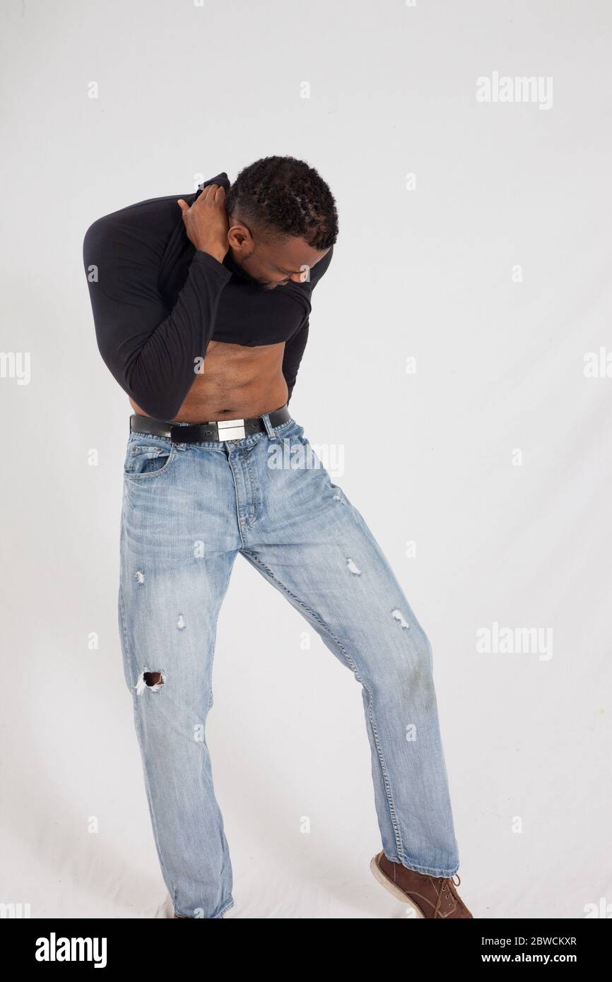Uomo nero in camicia nera, sollevandolo per esporre il suo addome Foto Stock