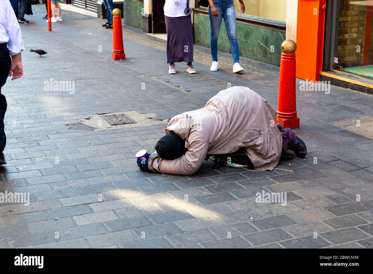 Mendicante mendicante per soldi per strada a Chinatown, Londra, Regno Unito Foto Stock