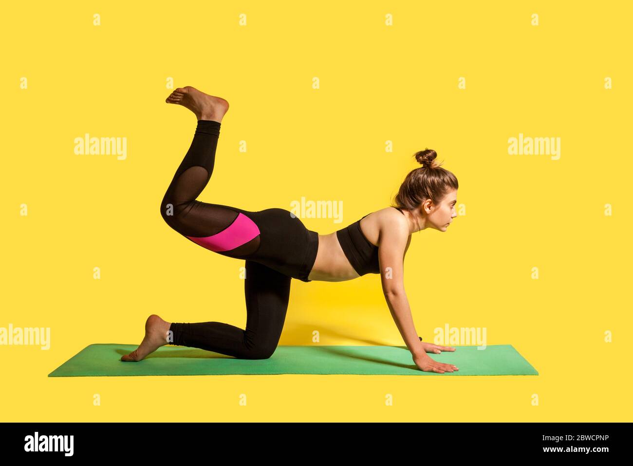 Donna fitness sottile con capelli bun in stretto sport pratica yoga, facendo una gamba gamba in posizione arco, allenamento muscolare flessibilità. studio shot, s Foto Stock