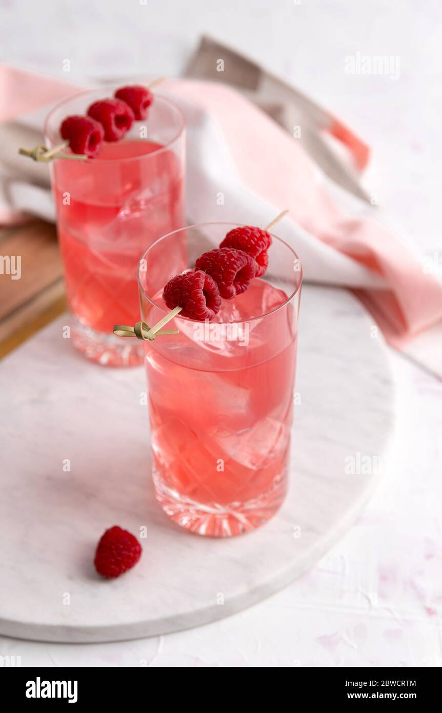 Cocktail rosa con lampone in vetro di cristallo sul tavolo Foto Stock