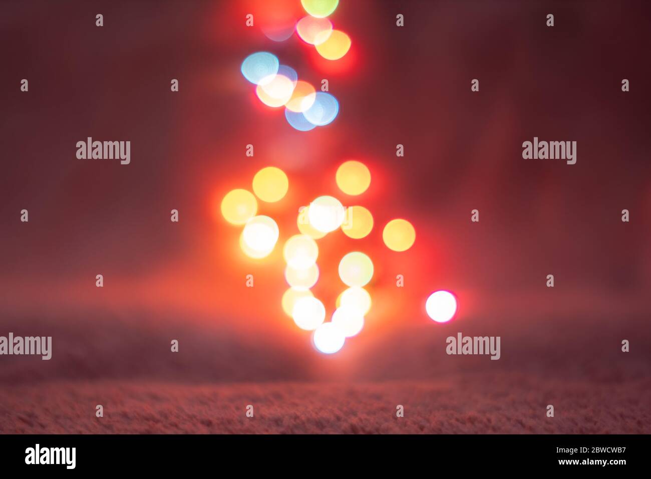 Astratto sfondo bokeh colorato sfocato con spazio di copia. Sfondo blu, rosso e dorato scintille scintillanti con effetto di bagliore, conca festiva e festiva Foto Stock