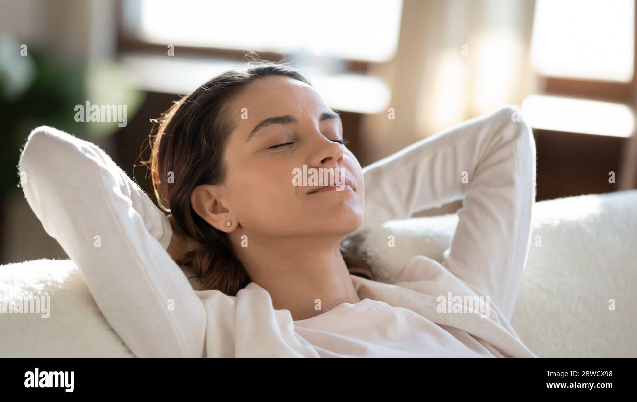 Calma giovane donna rilassarsi sul divano sognando Foto Stock