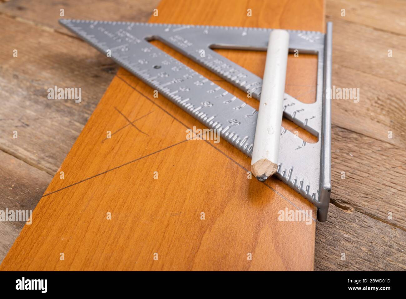 Disegnare una linea in un negozio di Falegnameria utilizzando una barra angolare. Piccoli lavori di Falegnameria in officina. Sfondo chiaro. Foto Stock