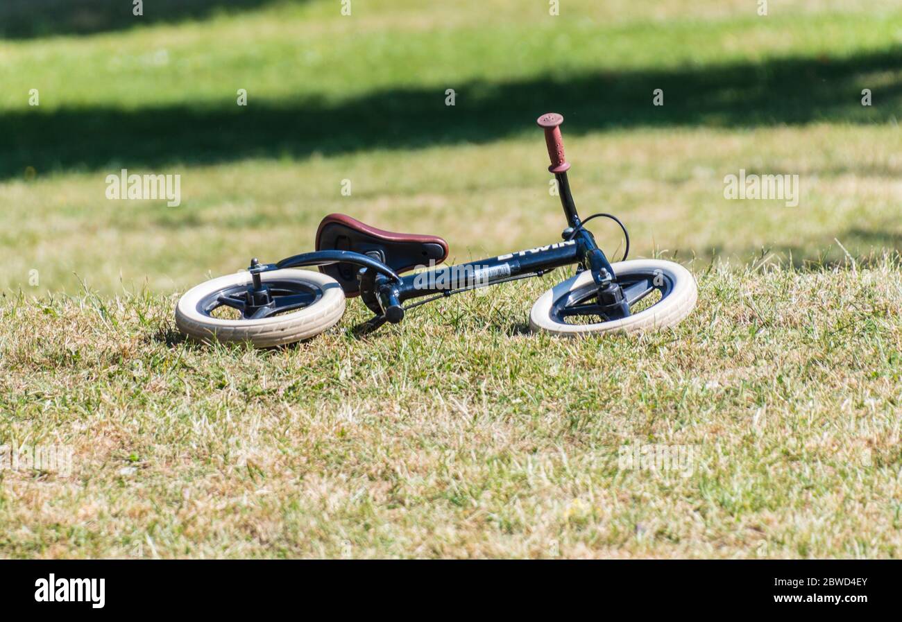 Bici Balance per bambini che giacciono sull'erba nel parco Foto Stock