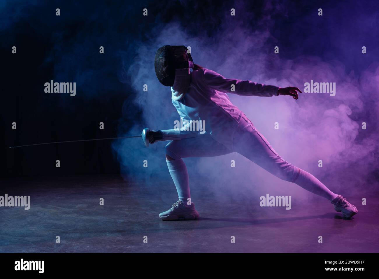 Spada scherma con pinza su sfondo nero con fumo colorato Foto Stock