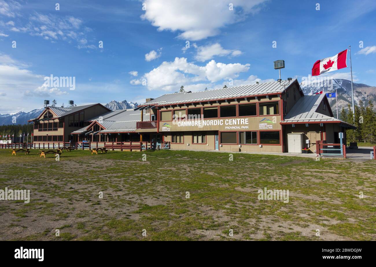 Canmore Nordic Center Provincial Park con esterno dell'edificio del Day Lodge e bandiera canadese nel pomeriggio di Sunny Springtime, Alberta Canada Foto Stock