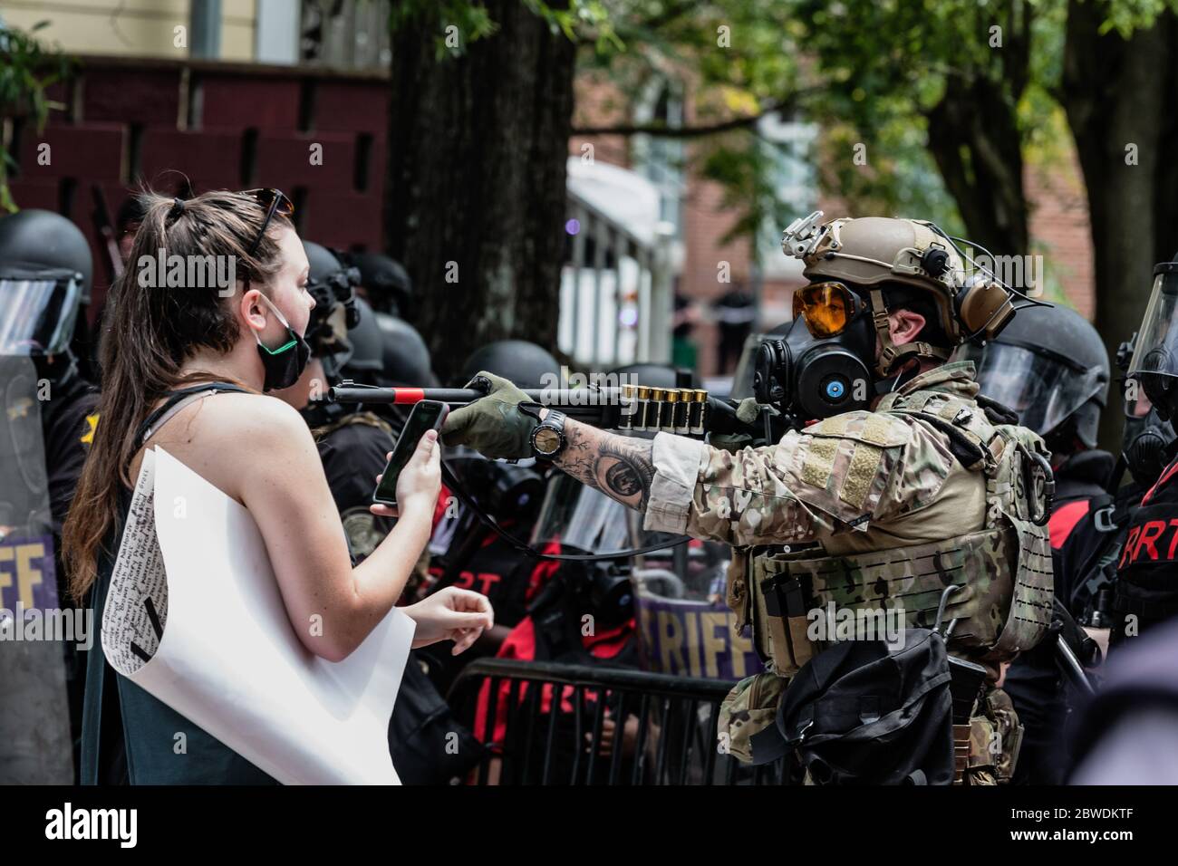 Columbia, South Carolina - USA - 30 maggio 2020: Una protesta disarmata ha attinguto una pistola su di lei mentre tenta di marciare al Columbia Police Department per protestare la brutalità della polizia contro le minoranze e la recente morte di George Floyd. La presenza delle forze dell'ordine nella città era pesante a causa dei disordini e delle saccheggi avvenuti il giorno precedente. George Floyd fu ucciso il 25 maggio 2020 a Minneapolis, Minnesota, mentre era in custodia di polizia. Gli onlookers guardarono mentre Floyd esprimeva la sua difficoltà a respirare mentre l'ufficiale Derek Chauvin si inginocchiò sul collo per nove minuti. La sua morte ha innescato na Foto Stock