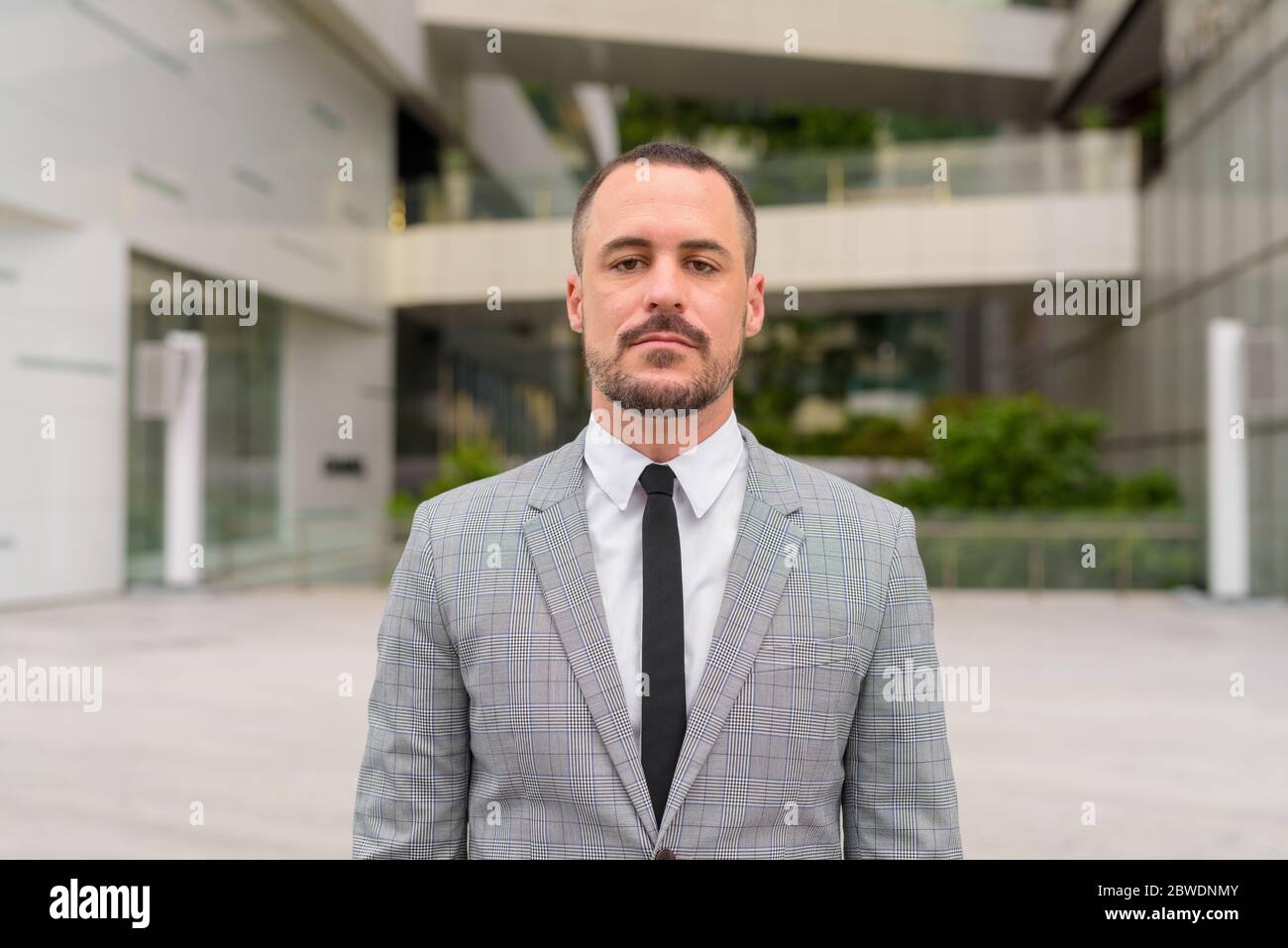 Bell'uomo d'affari con baldone ispanico in città all'aperto Foto Stock