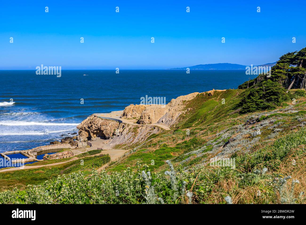 Rovine dei bagni Sutro al parco Lands End, scogliere con cipressi del pacifico e l'Oceano Pacifico sullo sfondo, a San Francisco, California Foto Stock