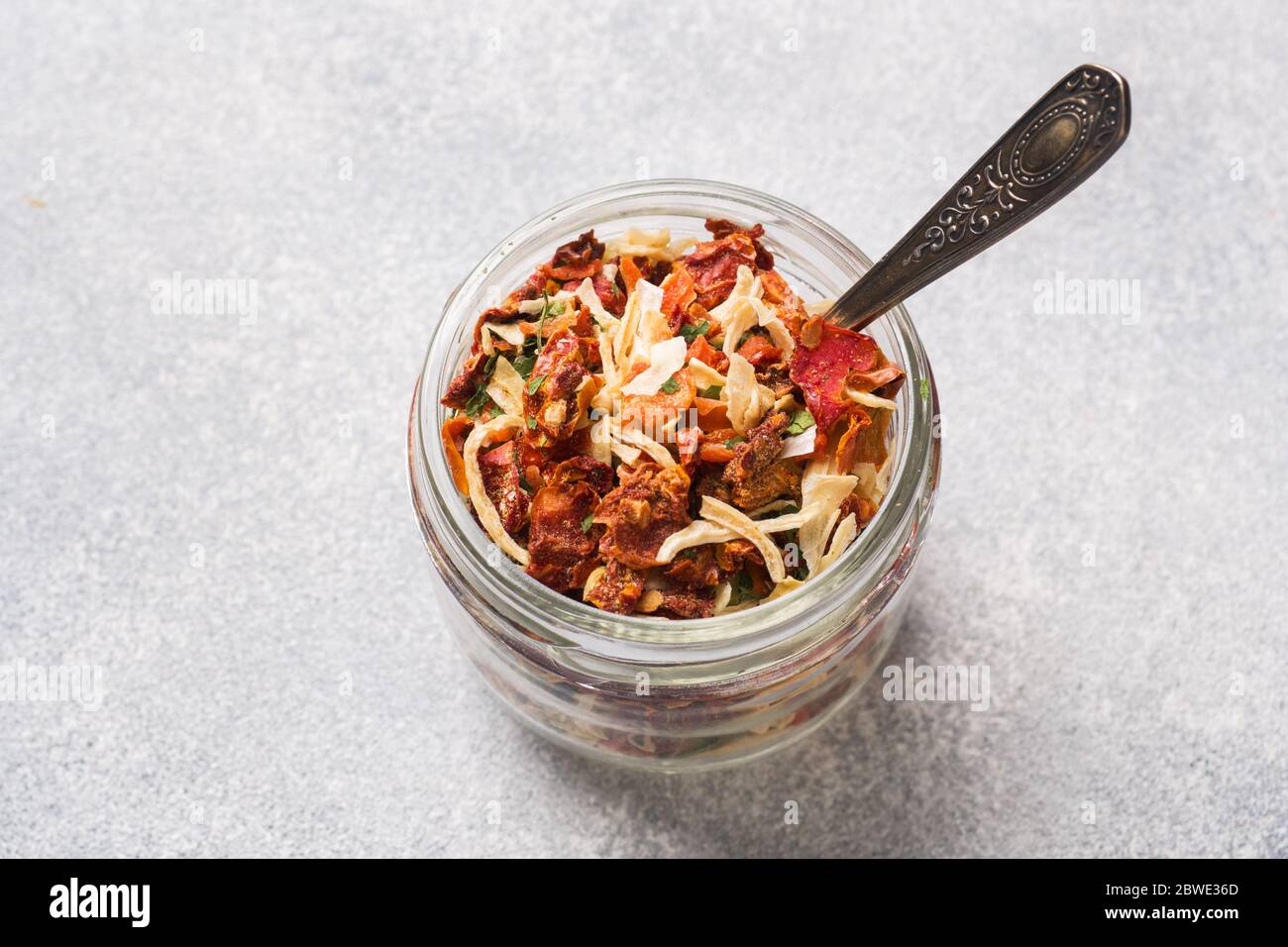 Spezie secche, pomodori secchi, carote secche, basilico e erbe della Provenza in un vaso di vetro spazio copia Foto Stock
