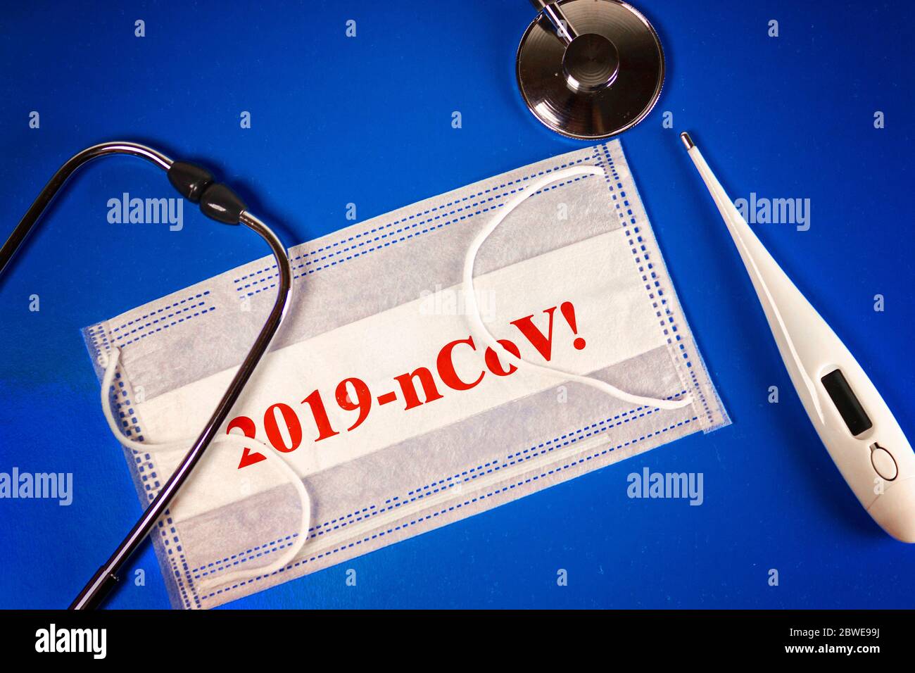 Stetoscopio, termometro e termometro maschera medica con 2019 nCoV su sfondo blu. Novel coronavirus - 2019-nCoV, CONCETTO di virus WUHAN. Foto Stock