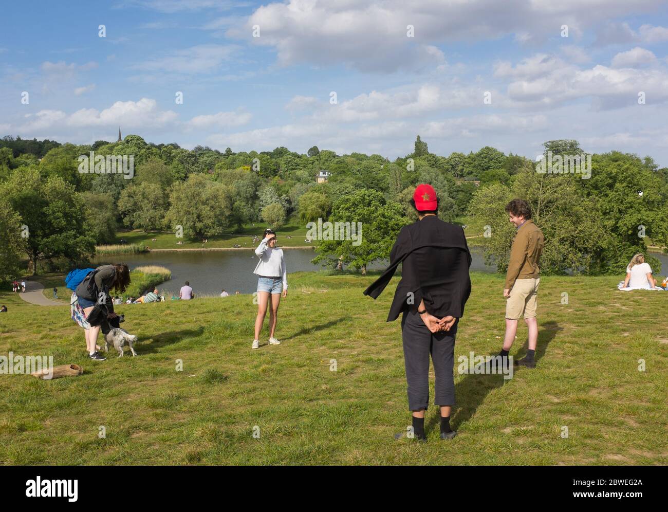 Gli amici osservano le distanze sociali su Hampstead Heath nel nord di Londra durante la fase di blocco della pandemia del coronavirus 2020 Foto Stock