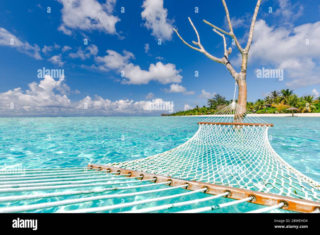 Amaca di lusso in paradiso isola laguna mare. Viaggio estivo in spiaggia e destinazione esotica vacanza. Paesaggio tropicale di viaggio ispirato spiaggia Foto Stock
