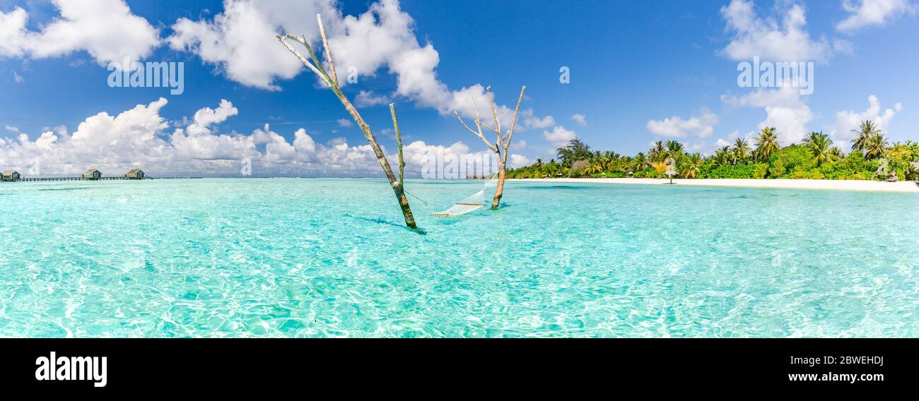 Amaca di lusso in paradiso isola laguna mare. Viaggio estivo in spiaggia e destinazione esotica vacanza. Paesaggio tropicale di viaggio ispirato spiaggia Foto Stock
