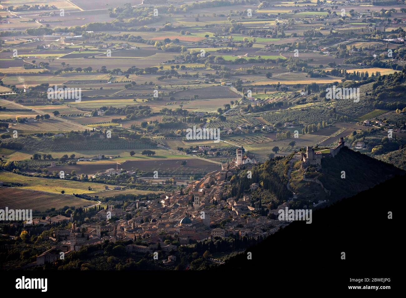 Assisi vista dall'alto, incorniciata dal Monte Subasio, che mostra tutta la pianura davanti ad essa Foto Stock