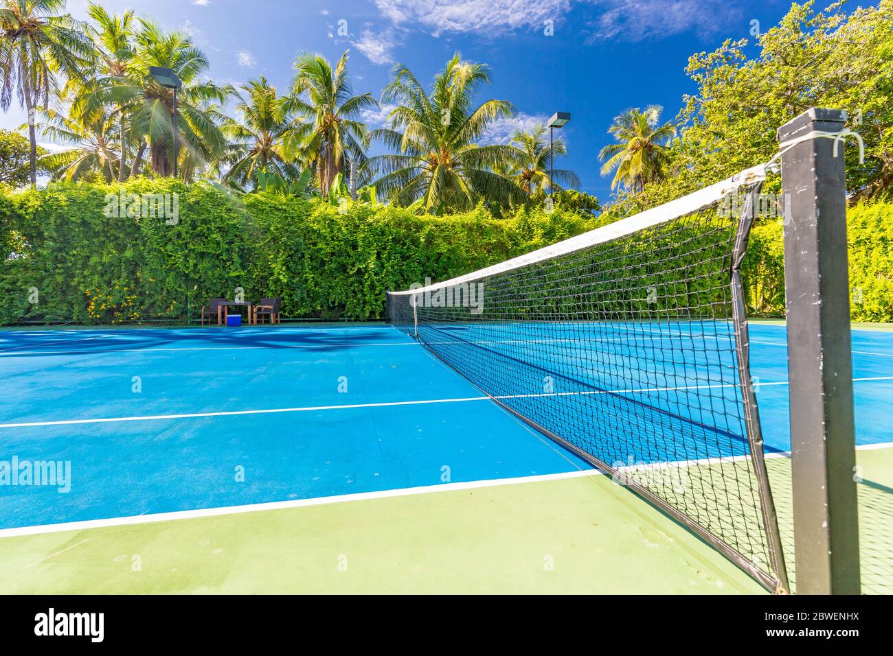 Sport e attività ricreative come campo da tennis su paesaggio tropicale, palme e cielo blu. Sport in concetto tropicale Foto Stock