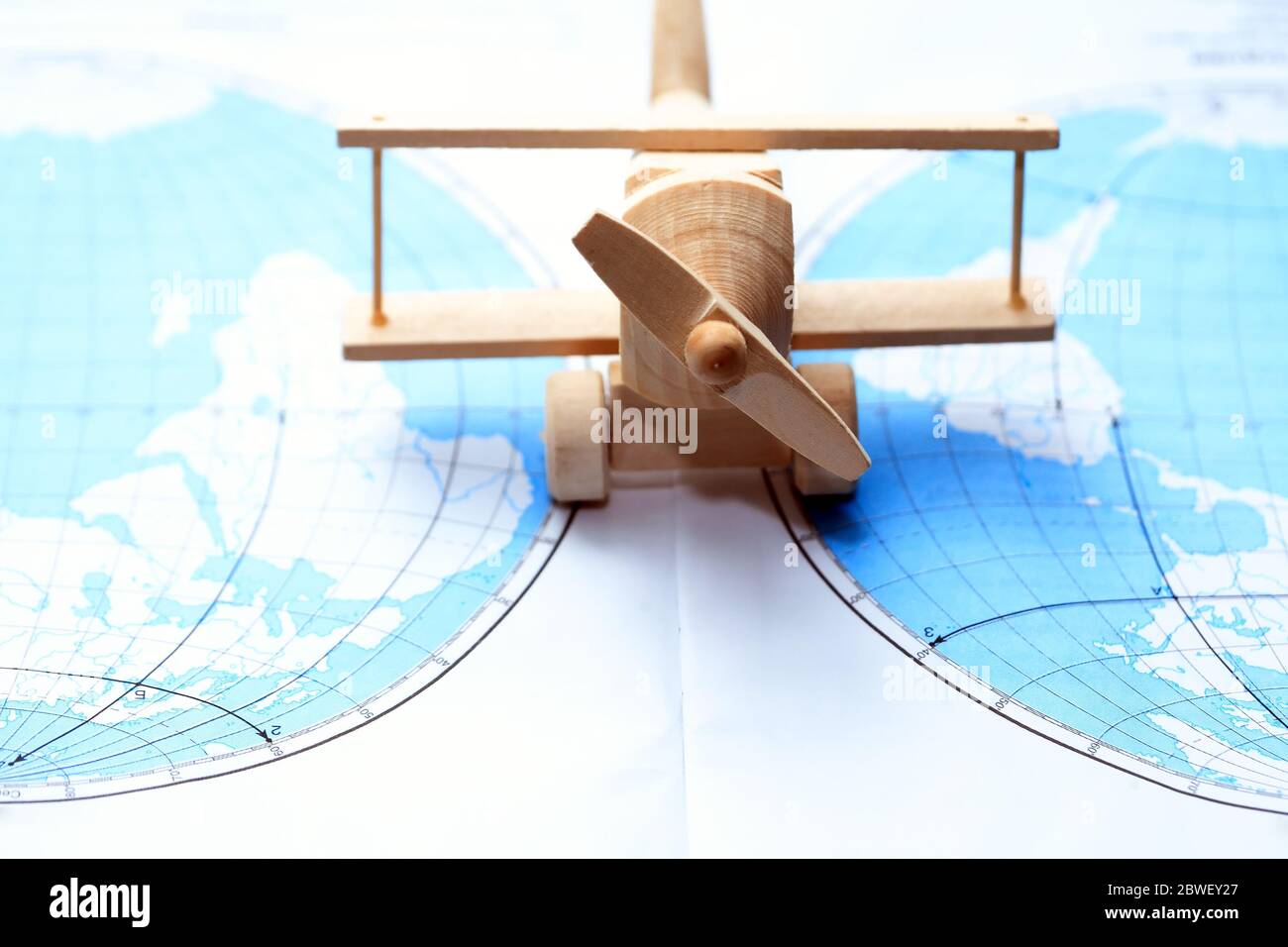 Concetto di viaggio. Piccolo aeroplano in legno sulla mappa tra due continenti Foto Stock