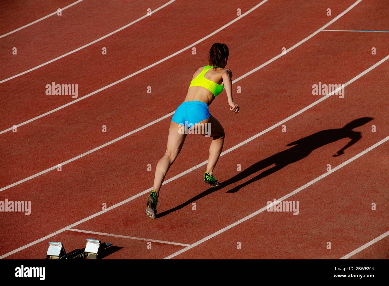 inizia 400 metri di corsa giovane donna runner nello stadio Foto Stock