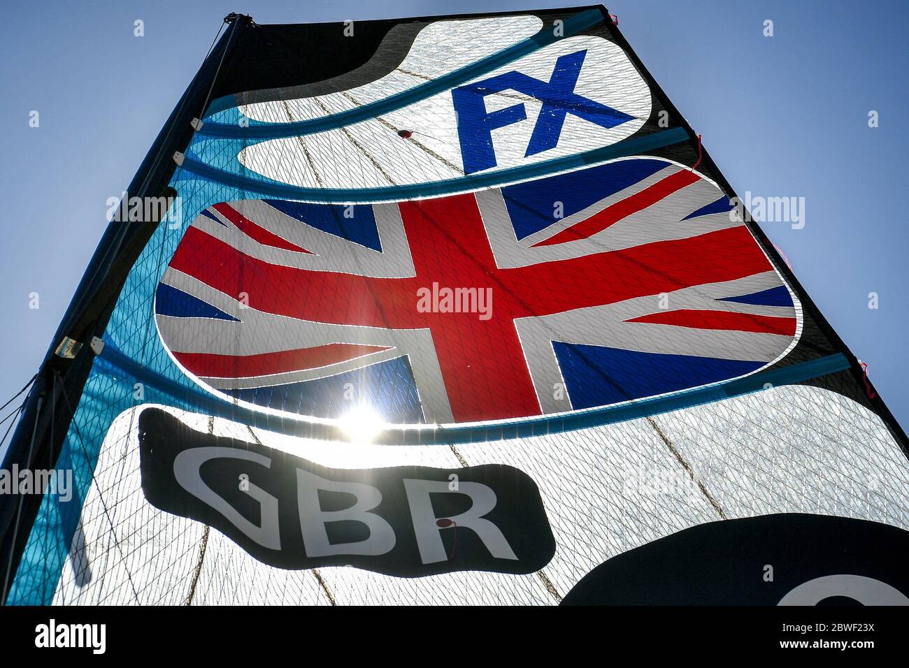 Il sole splende attraverso la vela di un 49er FX durante una sessione di allenamento, mentre i membri del Team GB a Weymouth e Portland National Sailing Academy tornano ad allenarsi in acqua a coppie, come le restrizioni di blocco in Inghilterra. Foto Stock