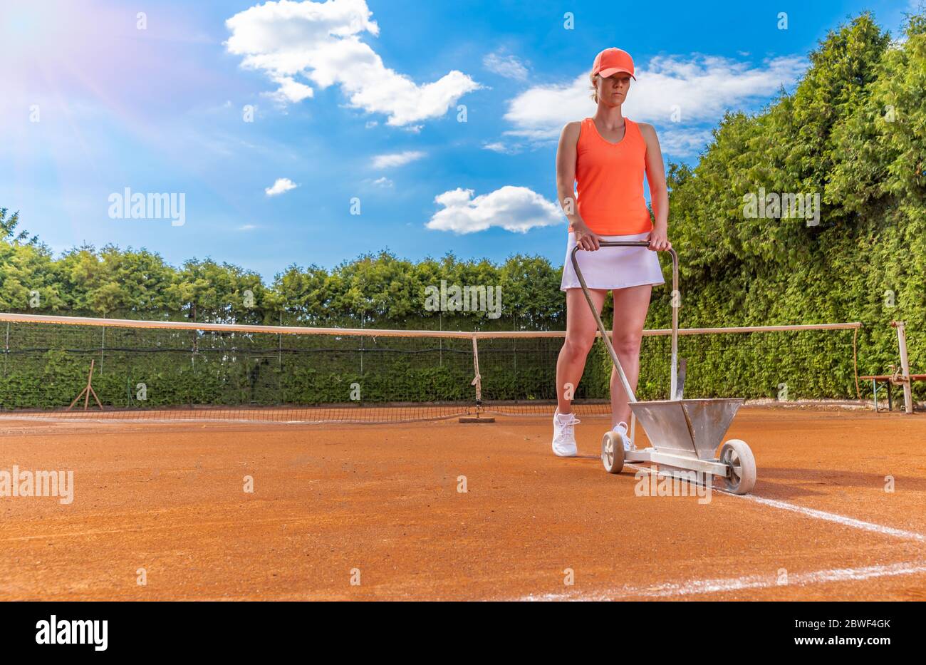 il tennista segna una linea bianca su un campo da tennis. spazio per le copie Foto Stock